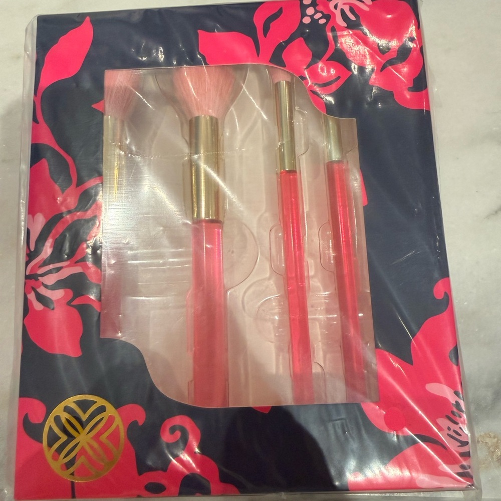 Lilly Pulitzer Pink makeup brushes and lit travel mirror.
